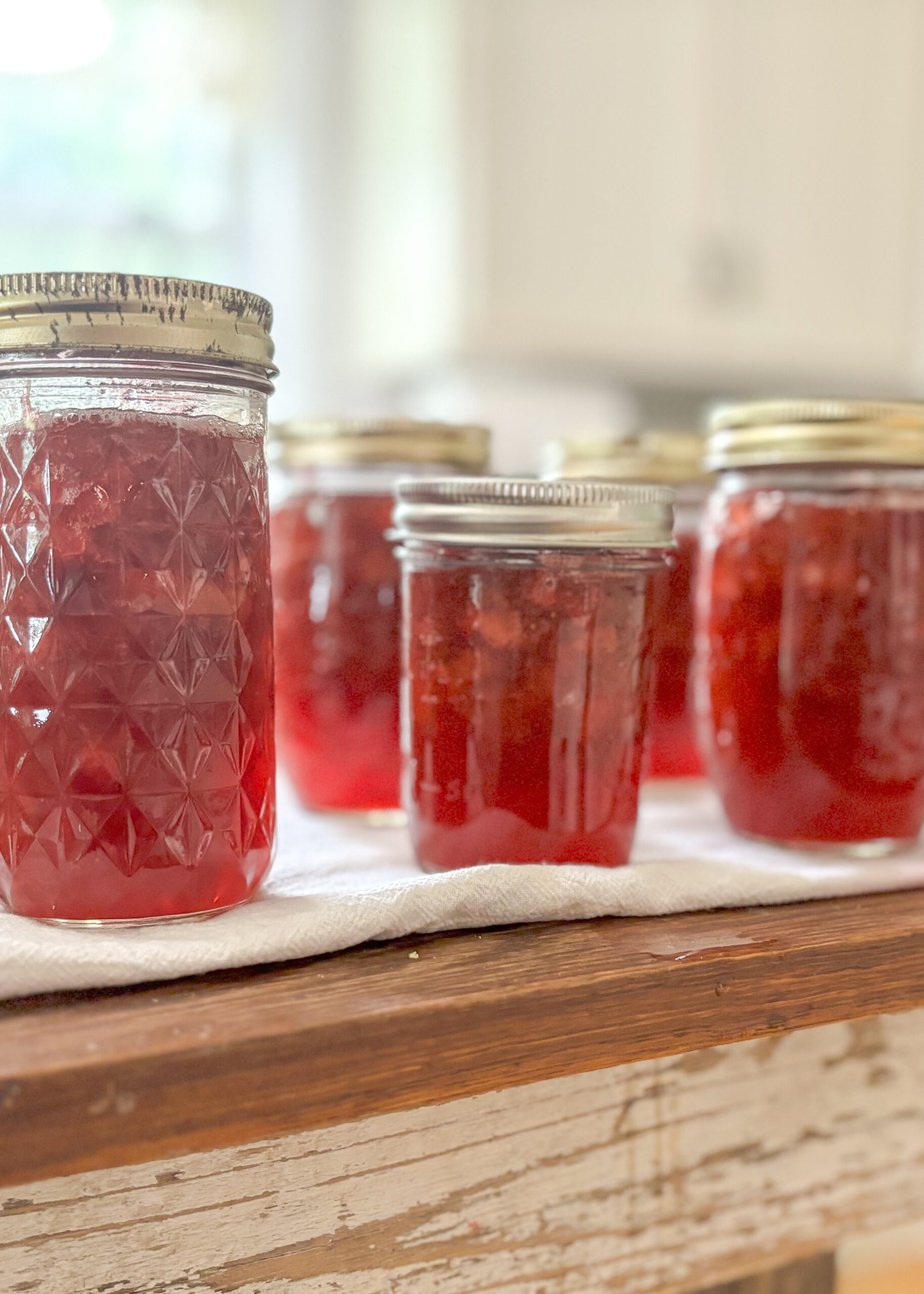 Beautiful image of canned strawberry rhubarb jam displayed in the kitchen