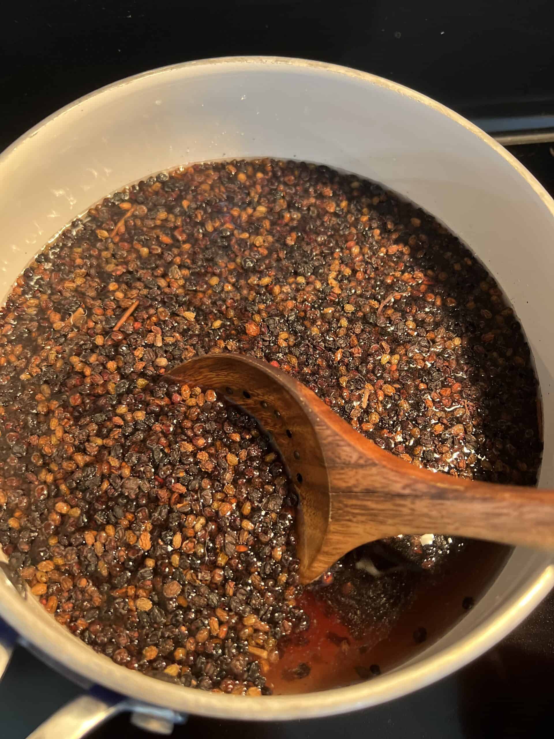 Homemade elderberry honey syrup for a natural immune support step one cooking on the stove