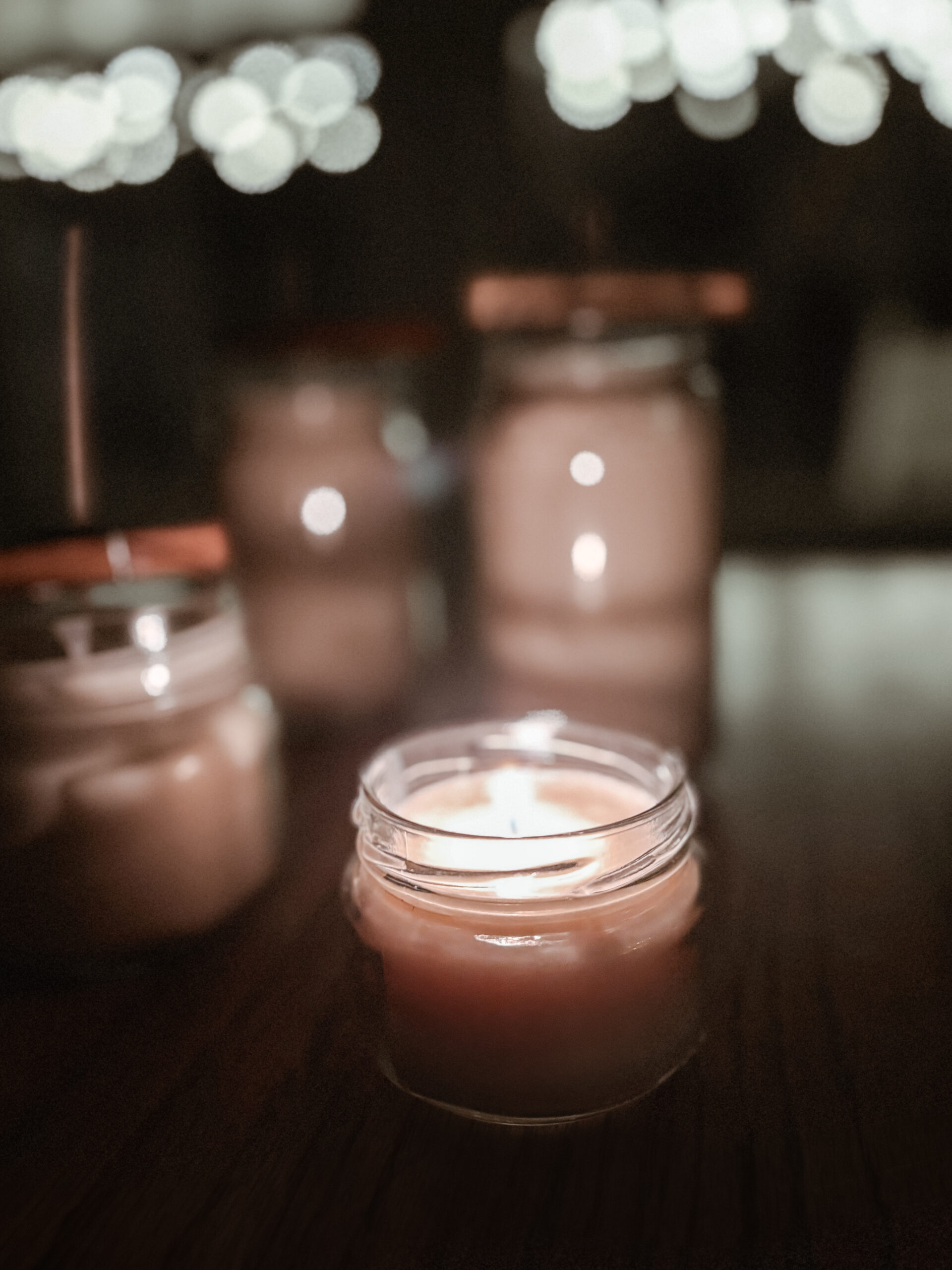 Finished beeswax candles burning in little jar