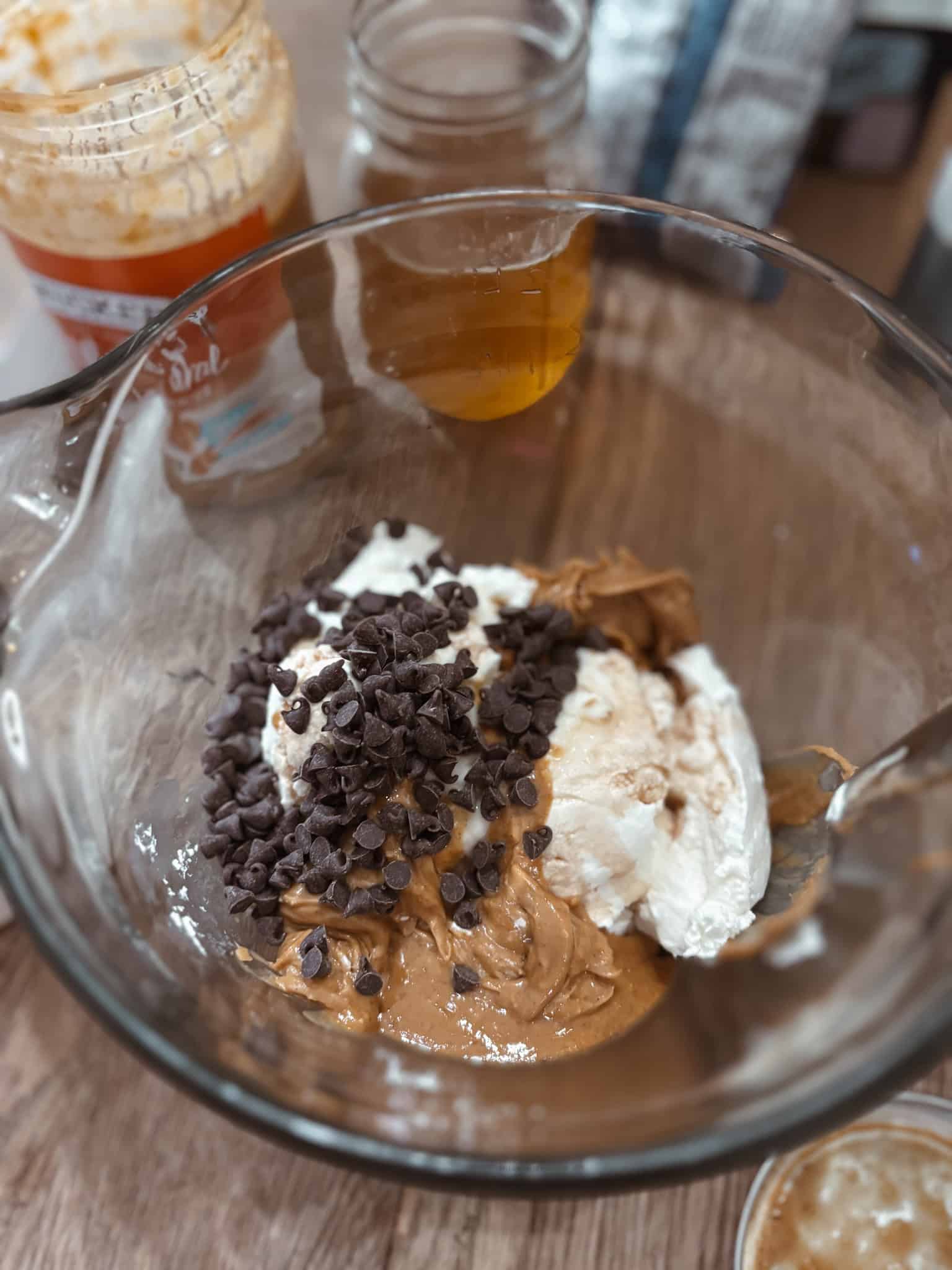 Mini homemade yogurt pops ingredients in a bowl, plain Greek yogurt, peanut butter, mini chocolate chips, vanilla 