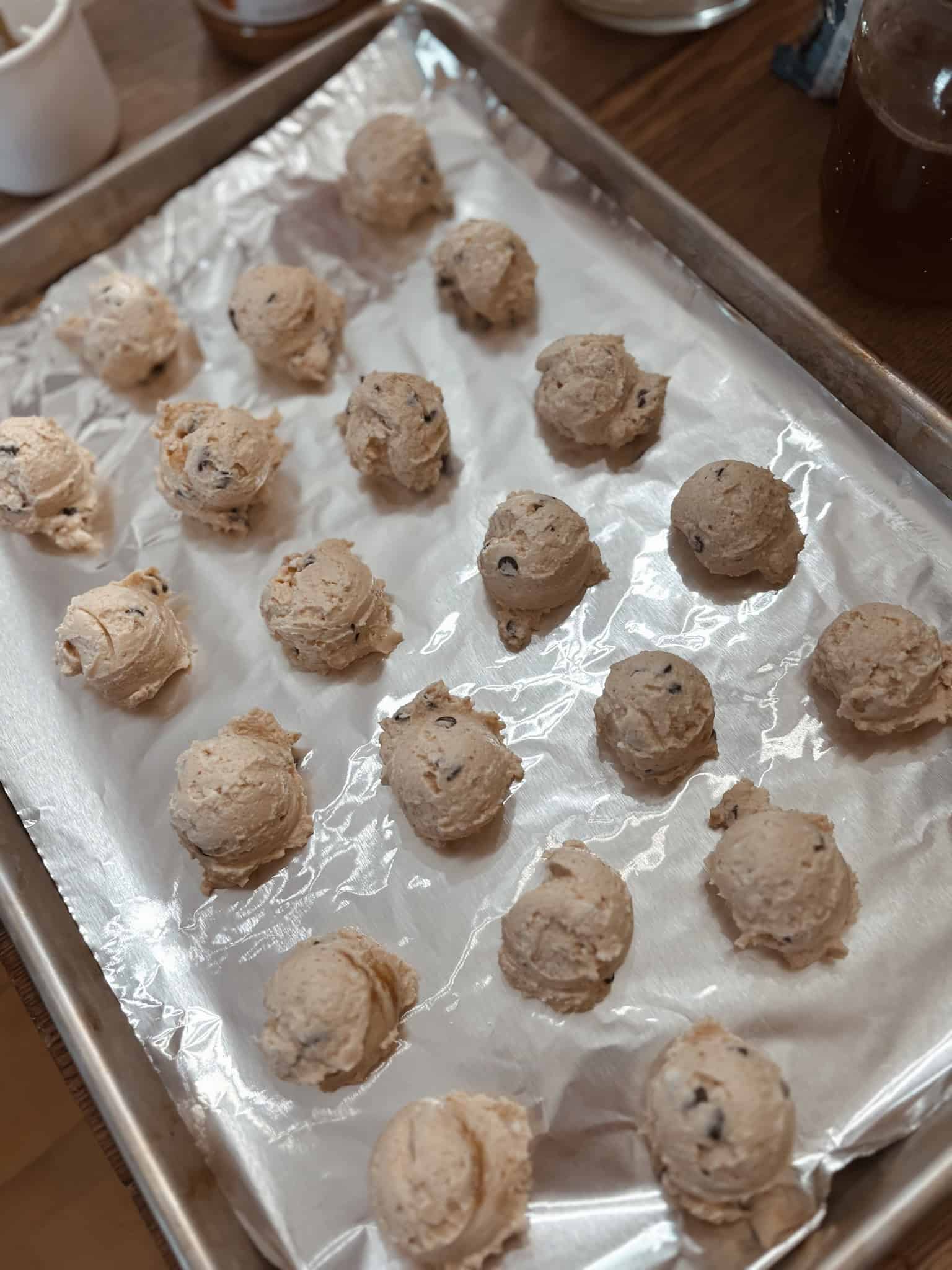 Mini frozen yogurt pops ingredients formed into little balls on the foil lined cookie sheet